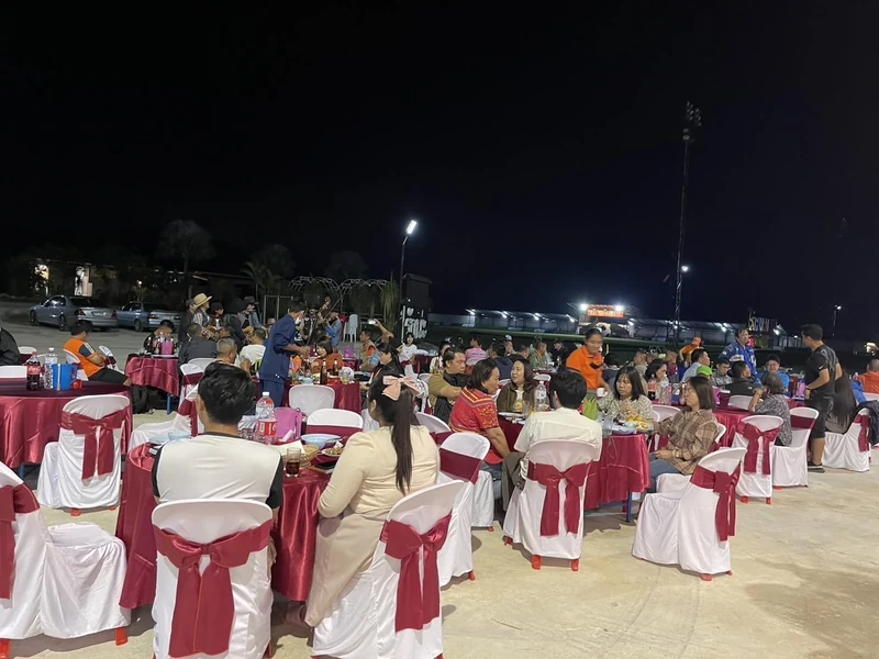 A large evening event dinner at dressed tables beside the pitch