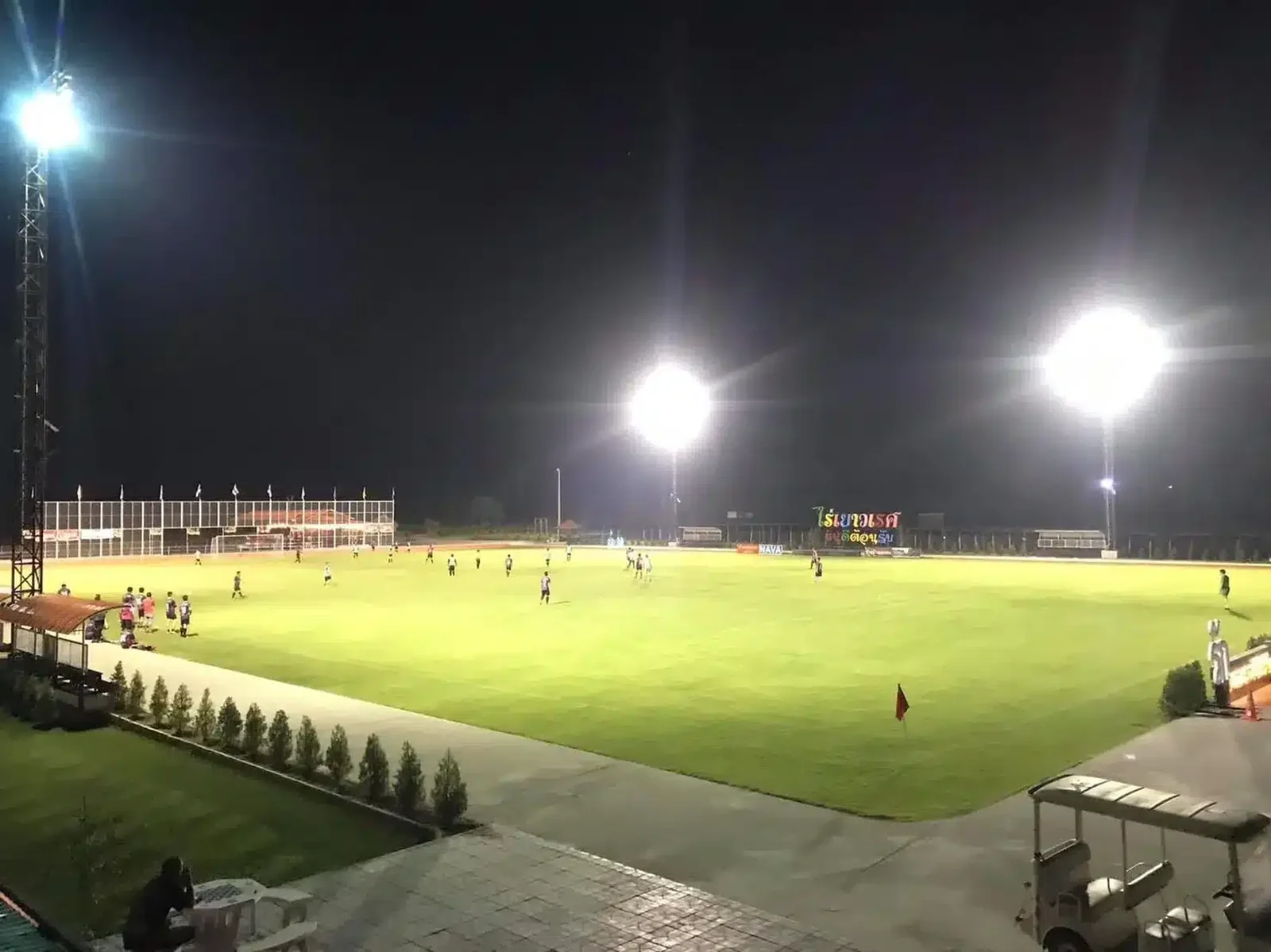 The main pitch under floodlights at night, with a squad training